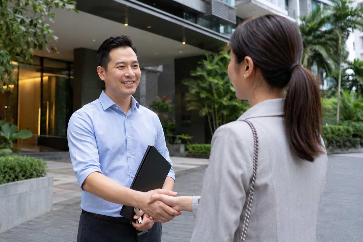 Buyer shaking hands with an agent outside a condo before buying HDB flat in Singapore